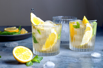 citrus lemonade with mint and lemon in the glass with ice cubes.