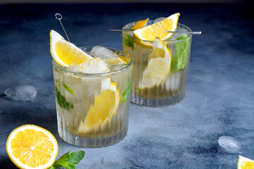 citrus lemonade with mint and lemon in the glass with ice cubes.