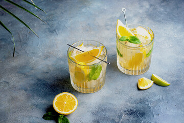 citrus lemonade with mint and lemon in the glass with ice cubes.
