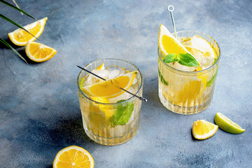 citrus lemonade with mint and lemon in the glass with ice cubes.