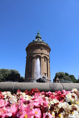 Wasserturm mit Brunnen und Blumen
