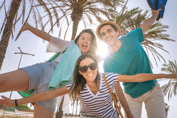 Multiracial group of friends happy laughing in the beach in summer after school.