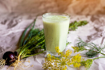 Drink in a glass. Green smoothie with yogurt or kefir. The composition is supplemented with herbs,...