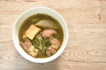 boiled mixed vegetable with pork belly and tofu in black soybean soup in bowl 