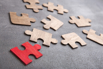 Creative idea and solve the problem concept. Teamwork success strategy - wooden puzzle on the grey background