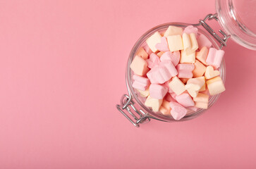 Obraz na płótnie Canvas Marshmallow in a glass jar on a pink background. Fruit flavored sweets. Strawberry marshmallow.Copy space. Place for text