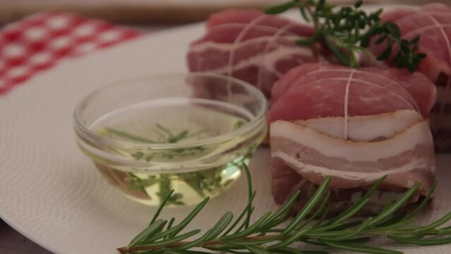 paupiettes de porc cru &agrave; l'huile et aux romarin dans une assiette 