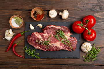 Raw beef steak on wooden table top. Healthy food concept. beef cut and spices for cooking bbq sauce