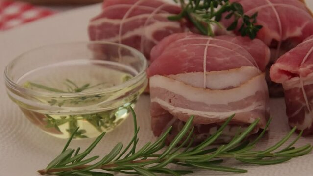 paupiettes de porc cru &agrave; l'huile et aux romarin dans une assiette 