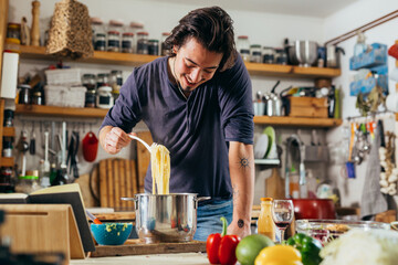 Fototapeta na wymiar caucasian young man preparing spaghetti in kitchen
