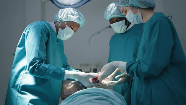 Team of surgeon doctors in operating room undergoing heart transplant surgery for patient to save life in the emergency surgical room. Close up hand doctor holding heart.