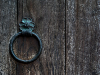 forged metal ring on a heavy wooden door, close-up textured background