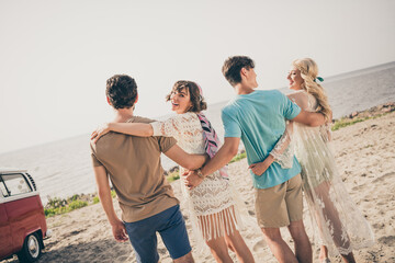 Photo of four people gathering carefree tourism 70s boho adventure wear casual outfit nature seaside beach