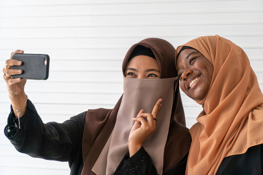 Muslim women smiling and playing with smartphone to selfie