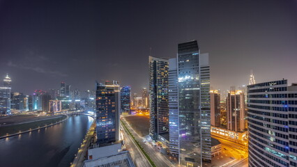 Fototapeta na wymiar Cityscape of skyscrapers in Dubai Business Bay with water canal aerial night timelapse