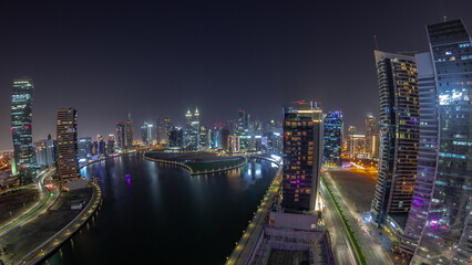 Fototapeta na wymiar Cityscape panorama of skyscrapers in Dubai Business Bay with water canal aerial night timelapse