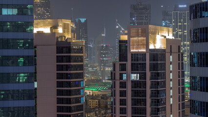 Skyscrapers in Dubai Business Bay and financial district aerial night timelapse.