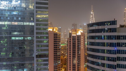 Skyscrapers in Dubai Business Bay and financial district aerial night timelapse.