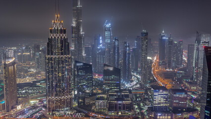 Fototapeta na wymiar Aerial view of tallest towers in Dubai Downtown skyline and highway night timelapse.