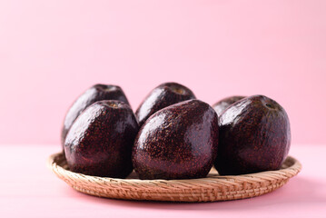 Ripe avocado fruit ready to eating on pink background