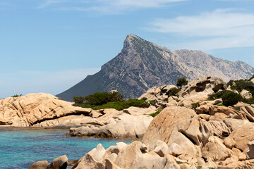 Beautiful sardinian sea shore landscape with granite rocks and Isola Cana in the background. - obrazy, fototapety, plakaty