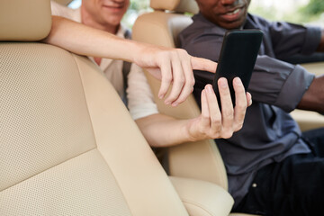 Closeup image of passenger showing destination point on map on smartphone