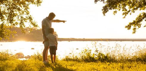 Father and his little son. Happy loving family walking outdoor in the light of sunset.