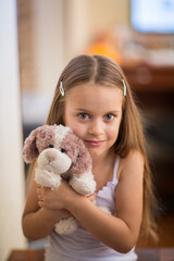 Portrait of a girl holding a plush dog toy.