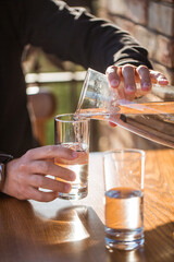 Man pouring water into glass. 