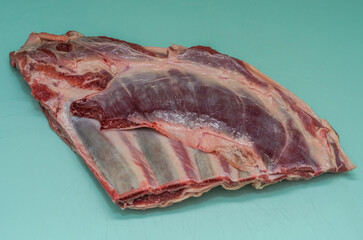 Butcher cuts lamb brisket with a knife on a cutting board