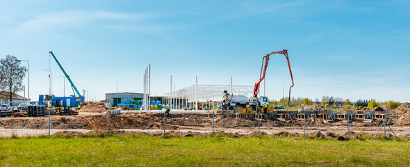 Urban area with machinery, car cement mixer,people are working on construction site.Panoramic...