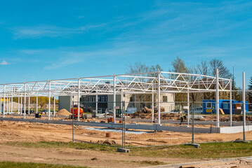 Urban area with machinery, people are working on construction site.Telsiai,Lithuania 05-10-2022.