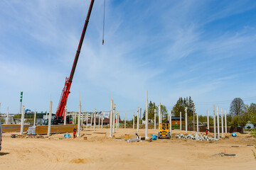 Urban area with machinery, people are working on construction site.Telsiai,Lithuania 05-10-2022.