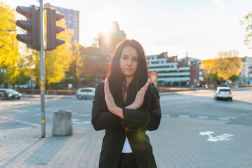 Pretty business woman with her arms crossed at her chest demonstrates break the bias symbol of...