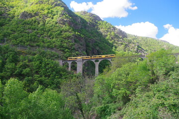 pont et petit train jaune pittoresque en montagne