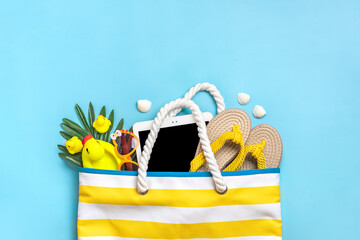 Swimming accessories - trendy beach bag with stripes, black glasses, white tablet, palm leaf,...