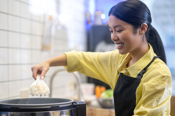 Woman standing near bowl preparing food in kitchen