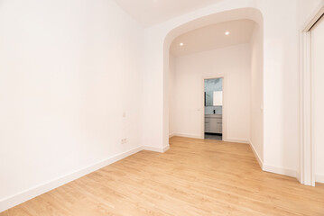 Empty room with oak parquet floor and white woodwork and carpanel arch and access to an en-suite bathroom