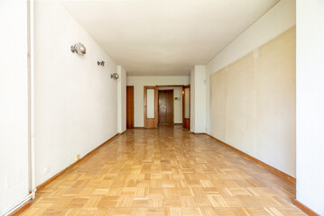 Empty room with oak parquet flooring, white painted walls and dark woodwork