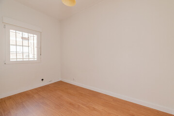 Empty room with oak parquet floor, white painted walls and white aluminum windows with a view