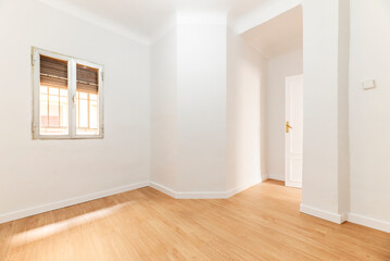 Empty room with oak parquet floor, white painted walls and aluminum windows