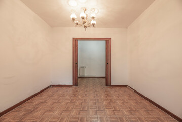 Empty living room with dark sliding wooden doors and imitation wood sintasol floor