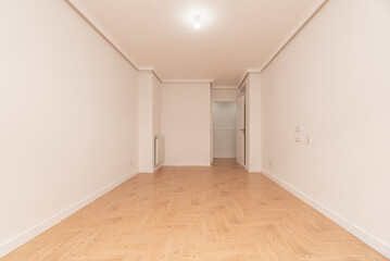Empty room with wood-like stoneware floors, white painted walls and aluminum radiator