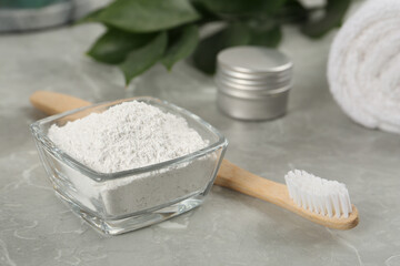Fototapeta na wymiar Tooth powder and brush on light grey marble table, closeup