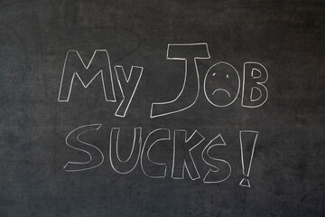 My job sucks written in chalk on a blackboard. Handwritten