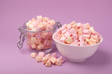 Marshmallow bowls on a lilac background.Closeup strawberry flavored chewy candy.Snacks and snacks for parties.Spice for coffee and cocoa.Winter food concept.Place for text.