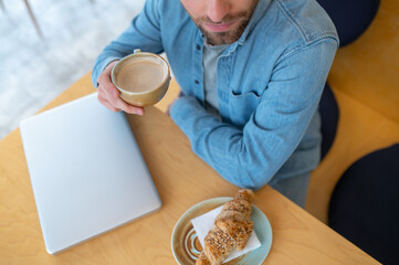 Top view of man with cappuccino sitting at table