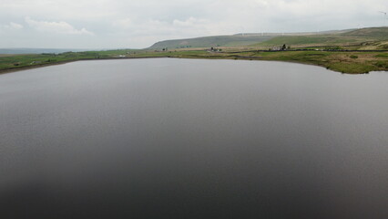 Aerial view of a lake surrounded by rural farmland and green countryside. 