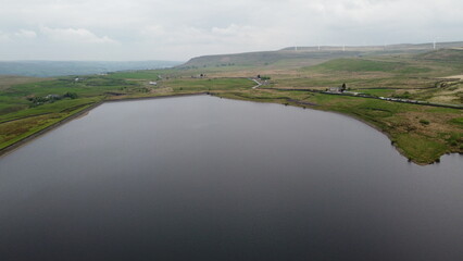 Aerial view of a lake surrounded by rural farmland and green countryside. 