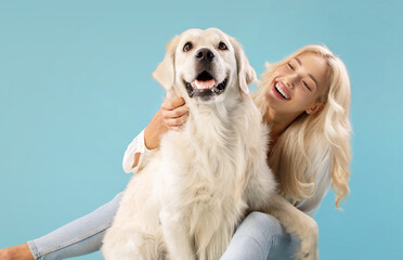 Pets and people concept. Happy young lady posing with her adorable golden retriever dog, sitting...